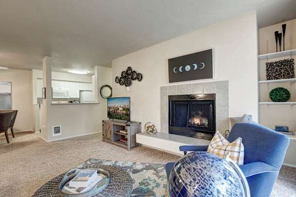 A living room with a fireplace and a blue chair.