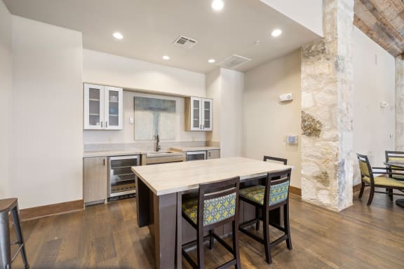 a kitchen with a large island with four chairs in front of it at Lakeline East Apartments, Cedar Park, 78613