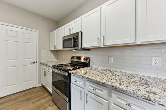 A kitchen with white cabinets and a granite countertop. at Sonterra Apartment Homes, Austin, TX, 78726
