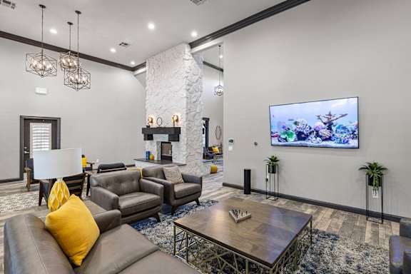 A modern living room with a stone fireplace and a flat screen TV.