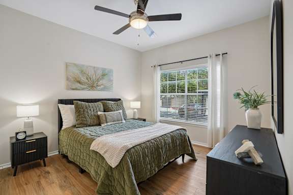 Bedroom with bedding and ceiling fan at Legends on the Green Apartments, San Antonio, Texas