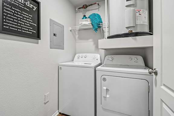A white dryer and washer in a small laundry room.