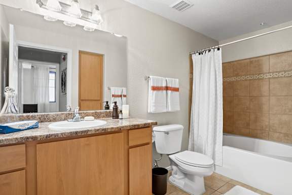 A bathroom with a white toilet, sink, and bathtub.