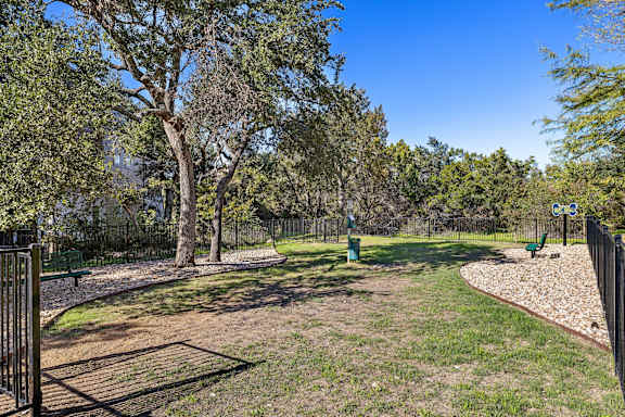 A park with a playground and a fence.