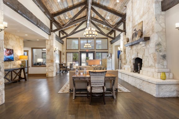 a dining room with a table and chairs in front of a stone fireplace at Lakeline East Apartments, Cedar Park, 78613