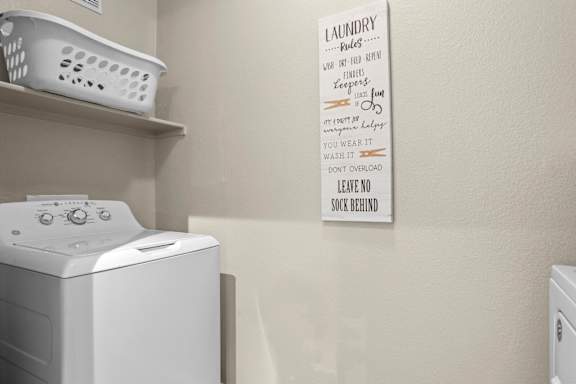 Laundry sign on a wall next to a washing machine.