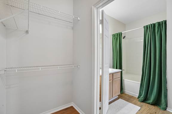 Walk-in closet with wire shelving and bathroom view at Legends on the Green Apartments, San Antonio