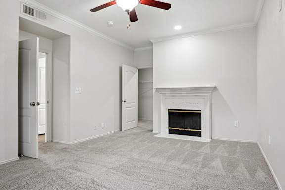 A room with a fireplace and a ceiling fan.