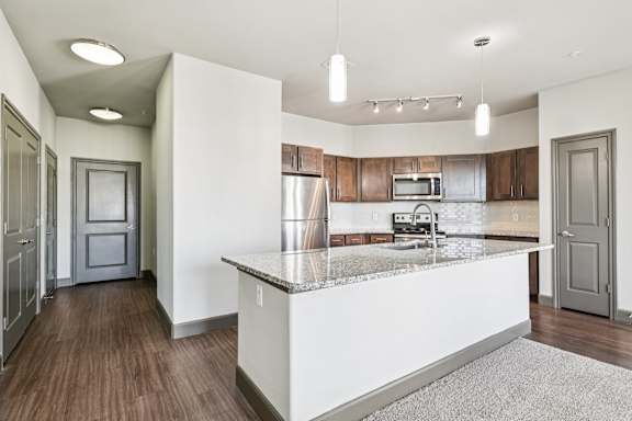 A kitchen with a white counter top and wooden floors.at North Creek, Hutto, TX