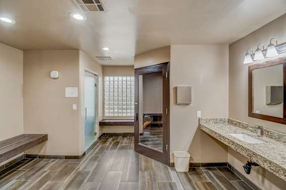 A bathroom with a wooden floor and a marble counter. at San Montego Apartments, Mesa, AZ