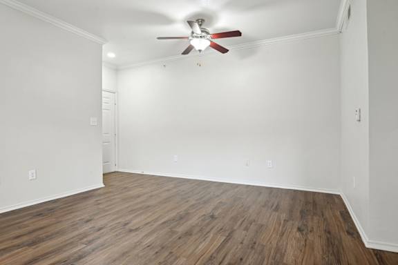 A room with a ceiling fan and wooden flooring.