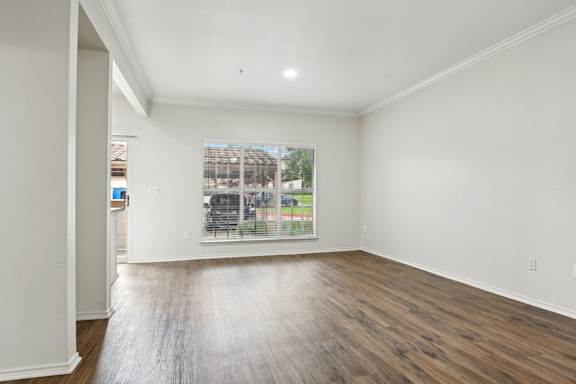 A room with wooden floors and a large window.