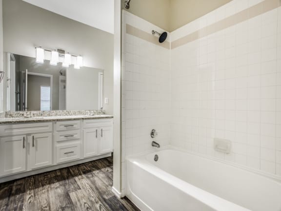 a bathroom with a bathtub and a sink at The Canyons Apartments, Fort Worth