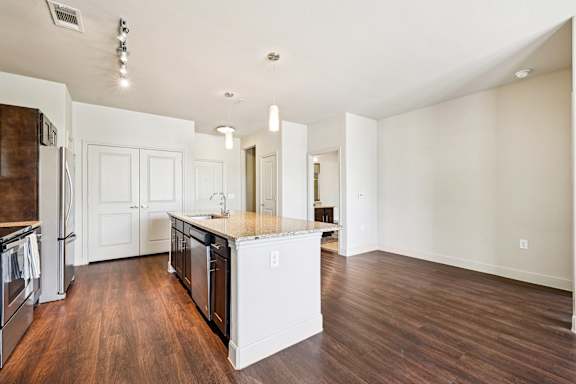 A kitchen with white appliances and wooden floors.at North Creek, Texas, 78634