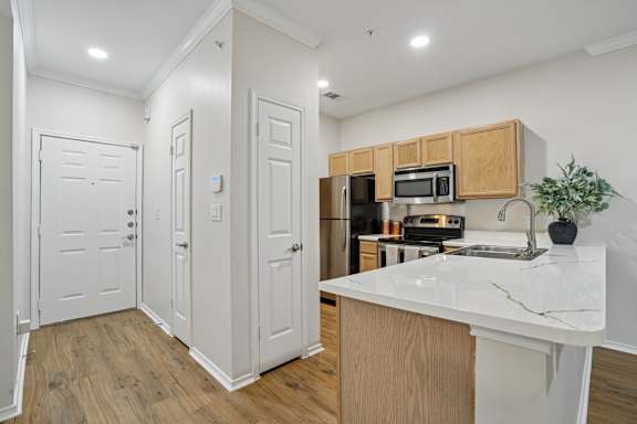 A kitchen with a white counter top and wooden cabinets.