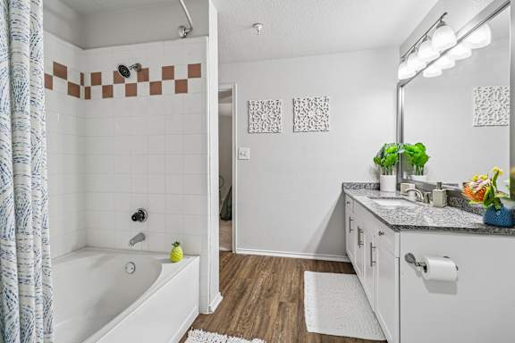 A bathroom with a white tub and a white sink.