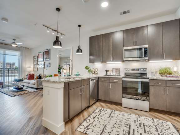 A modern kitchen with a white island and stainless steel appliances.