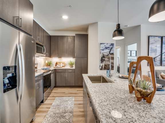 A modern kitchen with a stainless steel refrigerator and wooden cabinets.