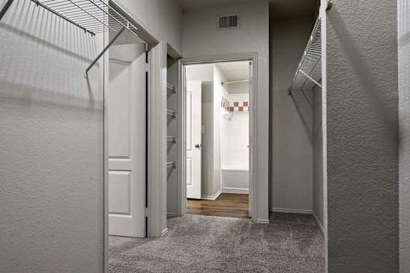 A hallway with a white door and a white wall.