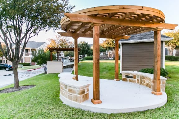 a patio with a stone table and a wooden pavilion in a yard at The Legends at Eagle Mountain Lake, Fort Worth