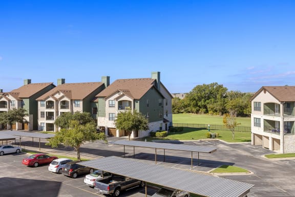 an aerial view of an apartment complex with a parking lot at The Fairways at Star Ranch, Hutto, TX