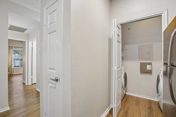 A white door is open to a laundry room.