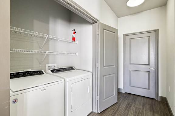 A laundry room with a washer and dryer and a door.at North Creek, Hutto, Texas