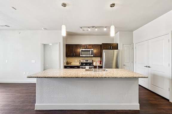 A kitchen with a granite countertop and stainless steel appliances. at North Creek, Texas, 78634
