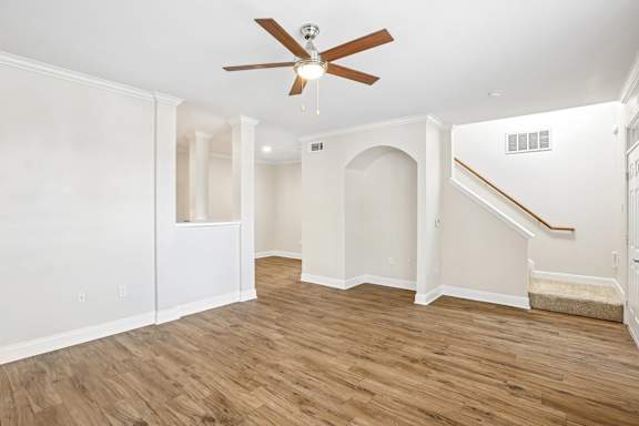 A room with a ceiling fan and wooden flooring.