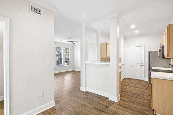 A kitchen with white walls and wooden floors.