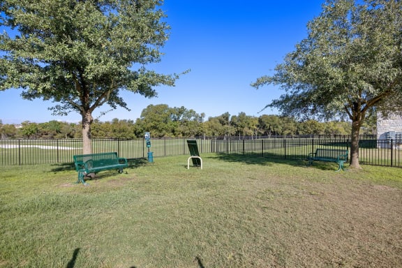 a park with benches and trees in front of a fence at The Fairways at Star Ranch, Hutto, TX, 78634