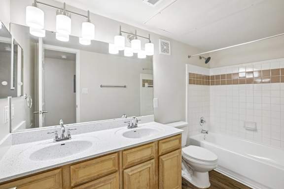 A bathroom with a white tub, sink, and toilet.