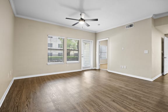 an empty living room with a ceiling fan and a window at Artisan Apartments &amp; Shops, Austin, TX