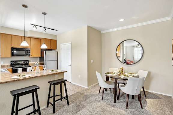 A kitchen with a bar area and a dining table.