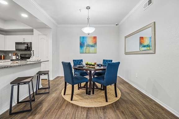 A dining room with a table set for four.