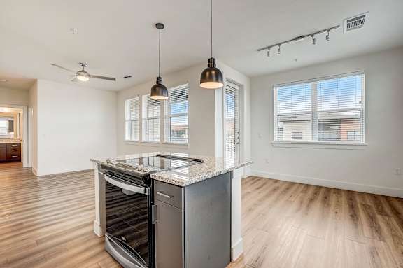 A modern kitchen with a large island and stainless steel appliances.