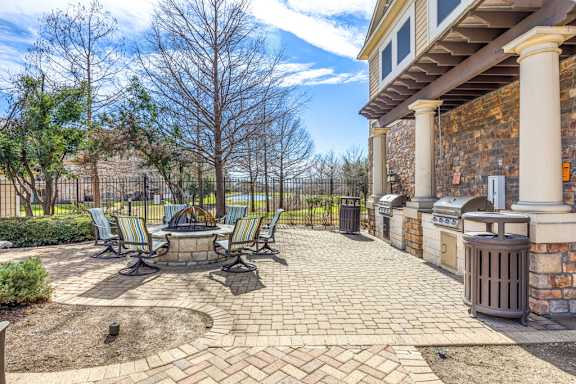 a patio with a fire pit and chairs at Las Brisas Apartment Homes, Round Rock, Texas