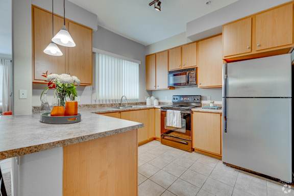 A kitchen with wooden cabinets and a granite countertop.