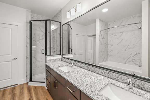 A bathroom with a marble countertop and a walk-in shower.