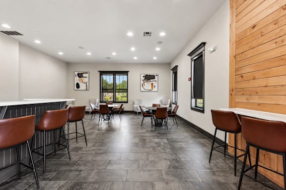 A room with a bar area and a dining table.