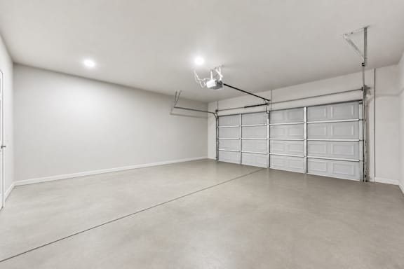 A spacious garage with a white wall and a white ceiling.