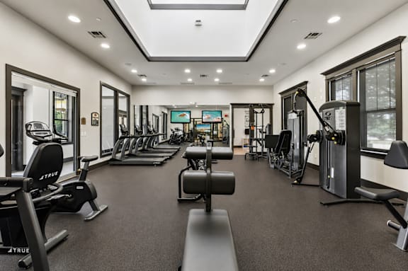 A well-lit gym with a variety of equipment.