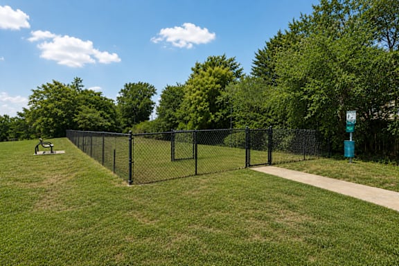 A park with a fence and a bench.