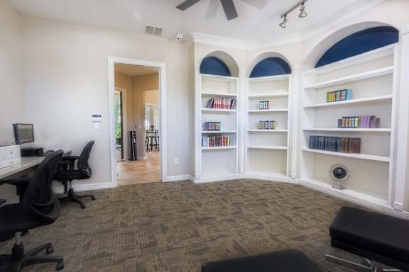 a home office with a desk and shelves with books at TalaVera Apartments, San Antonio, TX, 78232