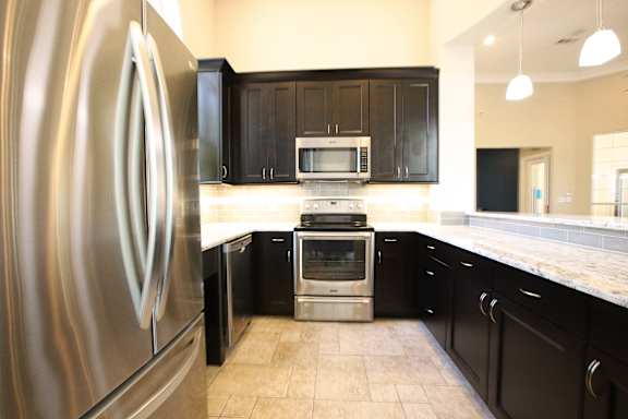 a kitchen with black cabinets and stainless steel appliances at TalaVera Apartments, Texas, 78232