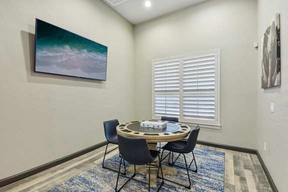A dining room with a round table and chairs.