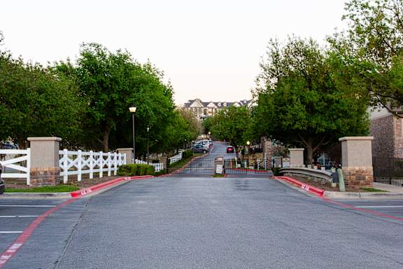 A street with a white fence and a red line on the side.