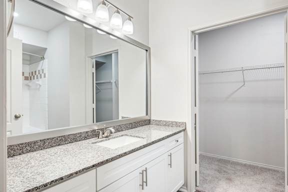 A bathroom with a sink, mirror, and a white door.