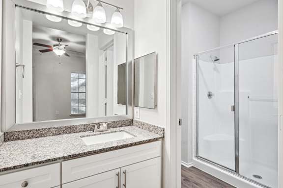 A bathroom with a white sink and a glass shower.