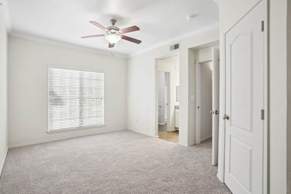 A room with a ceiling fan and a window with blinds.